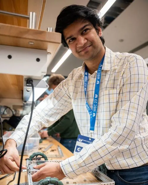 Aditya Dangra - Design Consultant, man wearing a checkered shirt assembling a mechanical structure