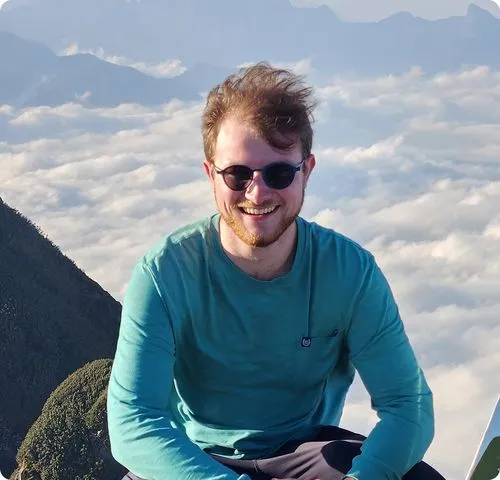 Finn Morin - Owner of Morin 3D, smiling man wearing sunglasses and a teal shirt outdoors with mountains in the background